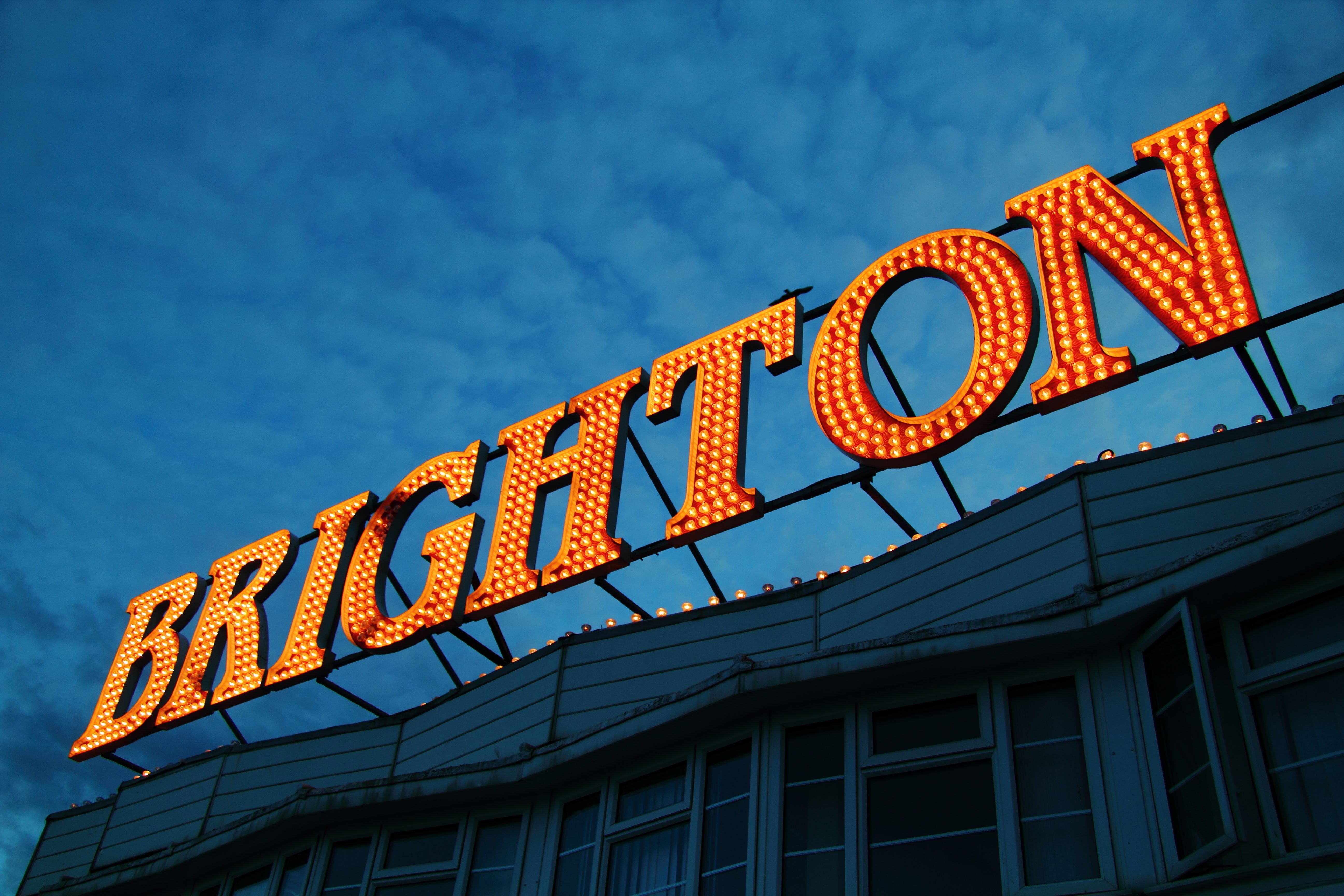 LED Light up, orange sign on top of building that reads ‘Brighton’